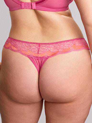 Person wearing pink lace underwear on a plain background