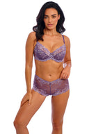 Woman wearing a purple lace lingerie set on a white background