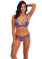 Woman wearing a purple lingerie set on a white background
