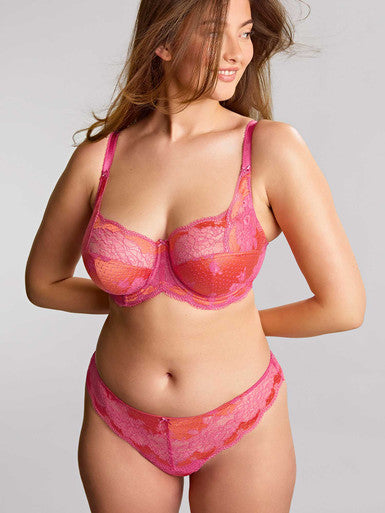 Woman wearing a pink lingerie set against a plain background